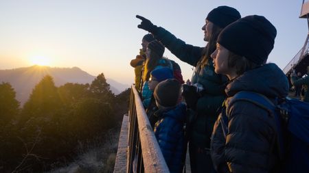 The Pelletier family watches the sunrise over a mountain in Nepal. (Credit: MRC/Jean-Sébastien Francoeur)