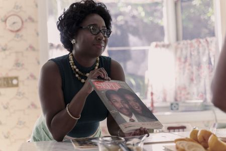 Juanita, played by Sasha Compère, holds up a magazine featuring the Kings in GENIUS: MLK/X. (National Geographic/Richard DuCree)