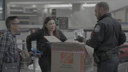 CBP Officer Mccants looks through a passenger's belongings in search of contraband or agriculture violations in Atlanta. (National Geographic)