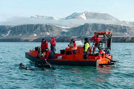 Crew John Chambers and David Reichert film in the water next to the FRC, as Aldo Kane, Eric Ste-Marie, Nigel Hussey, Melissa Marquez, Crew Josh Palmer, and Cameraman Jamie Holland ride in boat. (National Geographic/Mario Tadinac)