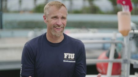 Dr. Mike Heithaus being interviewed on-board a boat in Miami, Florida as he discusses the comparison in shark bites and what he hopes to achieve on his dive. (National Geographic)