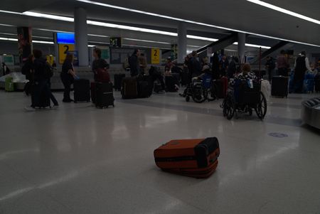 Multiple travelers wait for their luggage at baggage claim at the JFK International Airport, in New York. (National Geographic)