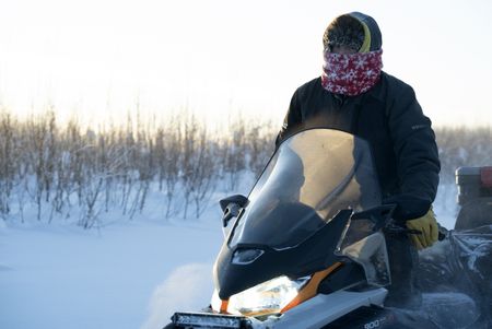 Tig Strassburg heads out on his snowmobile to set wolf and wolverine traps. (National Geographic/Pat Henderson)
