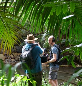 Neil Andison stands next to a camera man at the edge of Obi Creek. (Big Wave Productions)