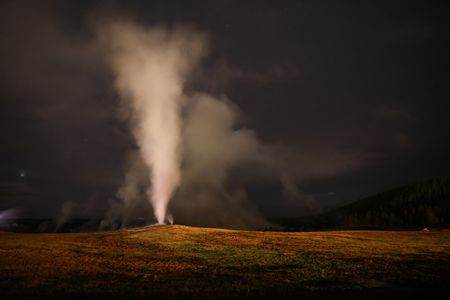 Old Faithful erupting at night.  (National Geographic/Jake Hewitt)