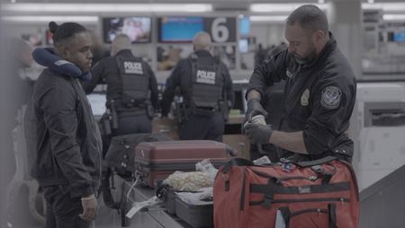 CBP Officer Mccants looks through a passenger's belongings in search of contraband and or agriculture violations in Atlanta. (National Geographic)