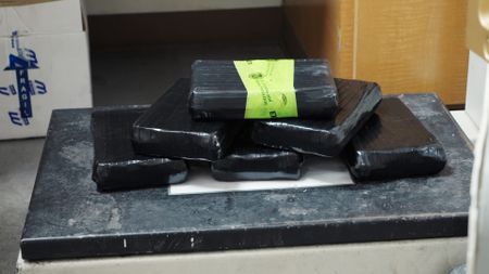 Multiple packages of suspected narcotics found smuggled in a suspect's vehicle are weighed on a scale in El Paso, Texas. (National Geographic)