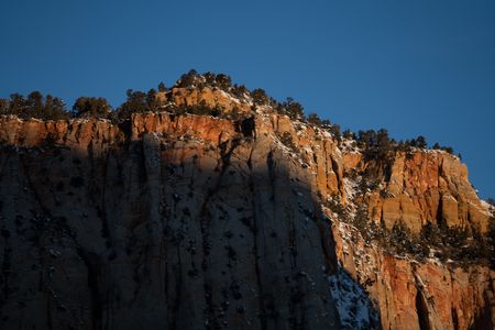 The rising sun casts shadows on a cliff face.  (National Geographic/Jeff Reed)