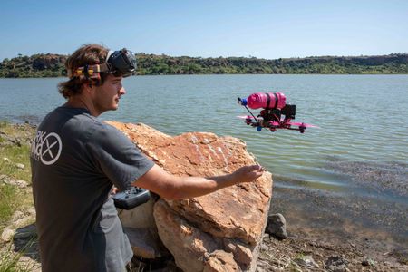 Ollie Lane catches a waterproof FPV drone after flying it over the lake. (National Geographic for Disney/Alex Minton)