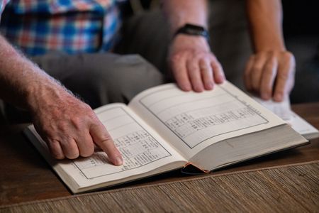 Mark Peterson points to where Awkwafina's family is recorded in the jokbo, a Korean book of genealogy. (Credit: National Geographic/Seong Joon Cho)