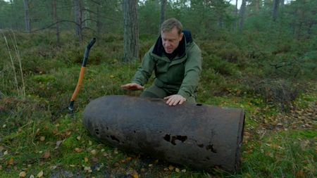 Andy rolling torpedo head through dirt. (National Geographic)