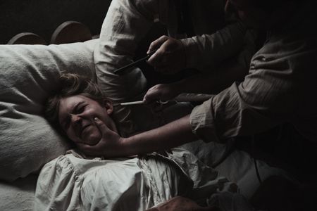 Mary Dunbar is held down in bed and prodded with quill pens. (Dash Productions Services LTD/Antoan Ivanov)