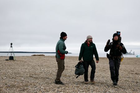 Eric Stackpole, David Reichert and PolarX guide Tom Lawton walking on Svalbard with a walrus cam set up in the background. (National Geographic/Mario Tadinac)