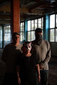 4th Eye Corporation members Sven, "Saturne" and "Valak" pose for a portrait in a warehouse. They are featured in "Killer Lies: Chasing a True Crime Con Man," a documentary series about obsession and deception, following the unraveling of Stephane Bourgoin’s career as a best-selling author and serial killer expert. The 4th Eye Corporation is an online group of true crime fans which formed in 2019 to investigate the details of Stéphane Bourgoin’s life and career. "Saturne" and "Valak" are pseudonyms. (National Geographic/Ben Selkow)