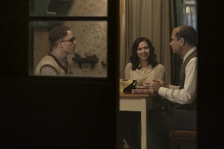 A SMALL LIGHT - Jan and Miep Gies, played by Joe Cole and Bel Powley, have dinner with Otto Frank, played by Liev Schreiber, as seen in A SMALL LIGHT. (Credit: National Geographic for Disney/Dusan Martincek)