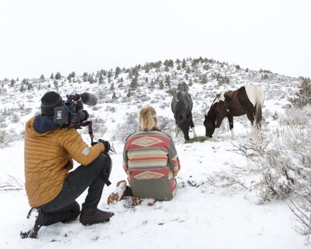 Clare and the cameraman with horses on a snowy hill. (Big Wave Productions)