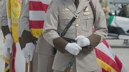 Officer stands in front of the American flag, as they remember a fallen officer in Mayaguez, P.R. (Lucky 8 TV/Ivan Leon)