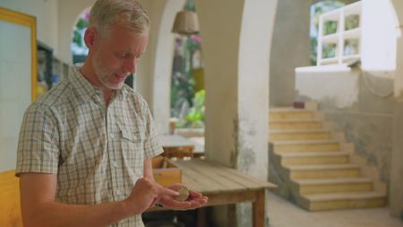 Henning Franzmeier inspects an ancient "Cartouche" in the Pi Ramesses site storeroom. (Windfall Films)