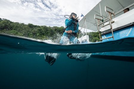 Dr. Alex Schnell enters the water in preparation to dive down and observe the Coconut octopus (Amphioctopus marginatus) in Lembeh Strait. (National Geographic for Disney/Craig Parry)