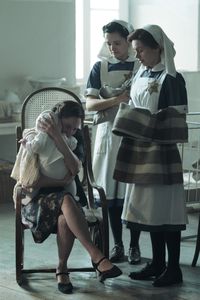 A SMALL LIGHT - Corry, played by Maya Gorkin, says goodbye to her baby as nurses Betje, played by Hannah Bristow, and Liesje, played by Sarah Winter, wait to take her to safety. (Credit: National Geographic for Disney/Dusan Martincek)
