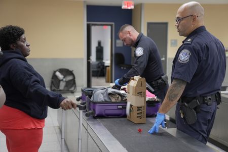 CBP Supervisory Officer Pacheco and CBP Officer Mccants question a passenger while going through their belongings in Atlanta, Ga. (National Geographic)