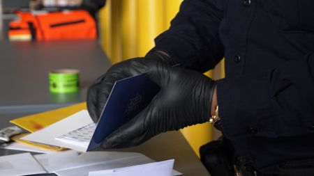 CBP Officer Rodriguez holds one of a number of mailed cards containing VIN numbers in Newark, N.J. (National Geographic)