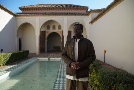 Onteka Nubio standing inside a courtyard in the Alcazaba Fort in Malaga, looking out onto Malaga city. Alcazaba was built to defend from Moorish armies in Spain. (National Geographic/Ciaran Henry)