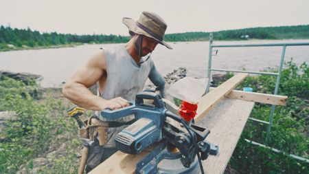 Matty works on lumber to prepare for his manmade dock. (Blue Ant Media)