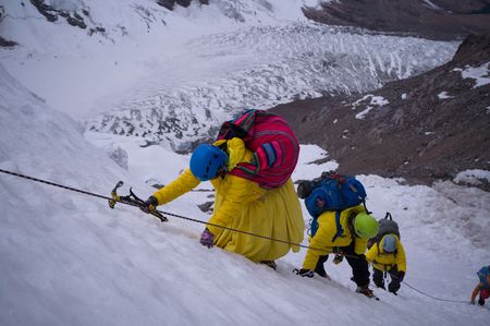 Cecilia Llusco climbs to Nevado Ausangate high camp on a fixed line with local guides and porters. (credit: National Geographic/Justen Bruns)