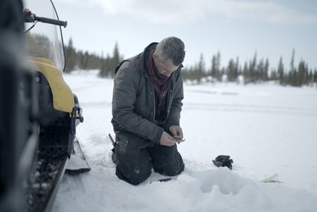 Joel Jacko sets a fishing line in the frozen lake. (National Geographic/Wayne Shockey)