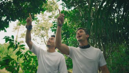 Henry Golding and Antoni Porowski spot a durian tree while walking through the Jungle. (National Geographic)