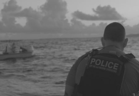 A CBP Agen overlooks a small boat at sea in Fajardo, PR. (Lucky 8 TV)