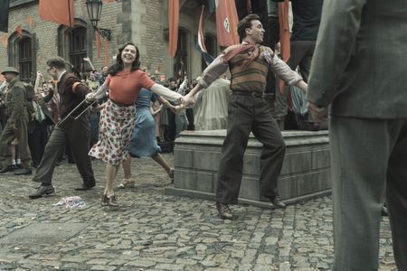 A SMALL LIGHT - Jan, Miep and Cas dance in a circle to celebrate Amsterdam's liberation from the Germans as seen in A SMALL LIGHT. (From left: Joe Cole and Jan Gies, Bel Powley as Miep Gies, and Laurie Kynaston as Cas). (Credit: National Geographic for Disney/Dusan Martincek)
