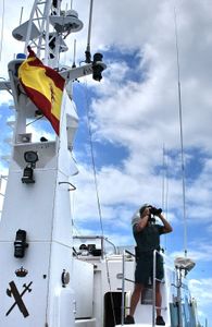 A guard uses binoculars to observe from the deck of a patrol boat in Marín, Pontevedra, Spain. (Guardia Civil)