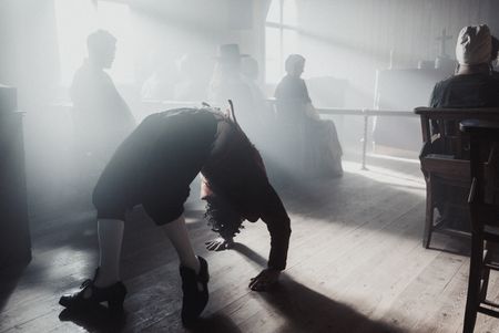 The Devil crawls into the church upside down on all fours, at the North Berwick witches sabbth. Sabbath visitors sit in the background. (Dash Productions Services LTD/Antoan Ivanov)