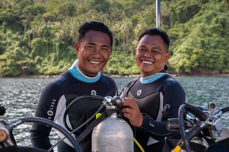 Renowned photographer and local dive guide, Benhur Sarinda, preparing for a dive on the Lembeh Strait with fellow dive guide, Rei Kanaling.  (National Geographic for Disney/Annabel Robinson)