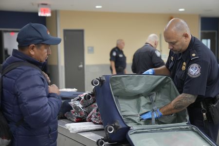 CBP Supervisory Officer Pacheco questions a passenger while going through their belongings in Atlanta, Ga. (National Geographic)