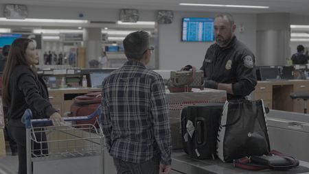 CBP Officer Mccants looks through a passenger's belongings in search of contraband or agriculture violations in Atlanta. (National Geographic)