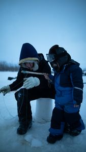 Tinmiaq Hailstone teaches her son Sabastian how to ice fish during the winter. (BBC Studios Reality Productions, LLC/Pedro Delbrey)