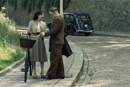 A SMALL LIGHT - Miep Gies, played by Bel Powley, waits for the bus with Jan Gies, played by Joe Cole, in A SMALL LIGHT. (Credit: National Geographic for Disney/Dusan Martincek)