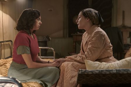 A SMALL LIGHT - Miep Gies, played by Bel Powley, talks with Edith Frank, played by Amira Casar, in the secret annex, as seen in A SMALL LIGHT. (Credit: National Geographic for Disney/Dusan Martincek)