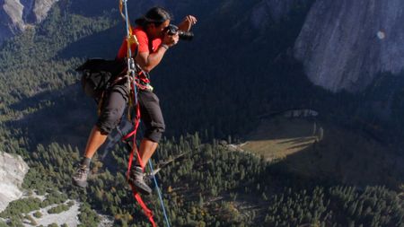 Jimmy Chin (left), using ropes, jumps from a wall to take a photo.  (credit: Jimmy Chin Productions)
