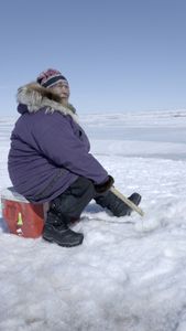 Teresa Pingayak with her grandson, Asher Ulroan ice fishing. (National Geographic/Matt Kynoch)