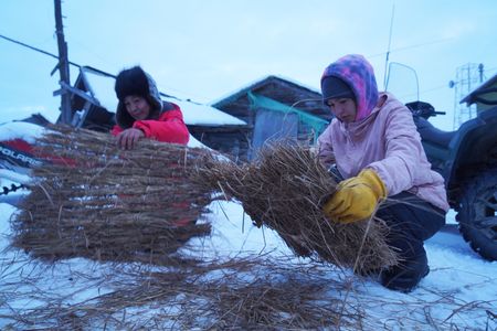 Agnes Hailstone and her daughter, Carol make grass  matts to use while fishing on the frozen river. (BBC Studios Reality Productions, LLC/Dwayne Fowler)