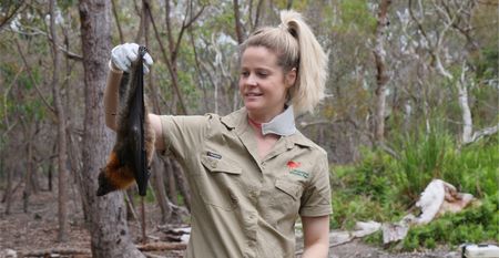 Sarah in the forest holding a bat upside down. (Big Wave Productions)