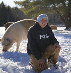 Todd Friedman knelt in snow with0 pig behind (Big Wave Productions