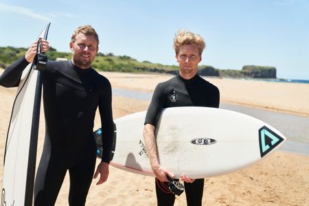 Brett Connellan and Joel Trist with their surfboards at Bombo Beach. (National Geographic/Justine Kerrigan)