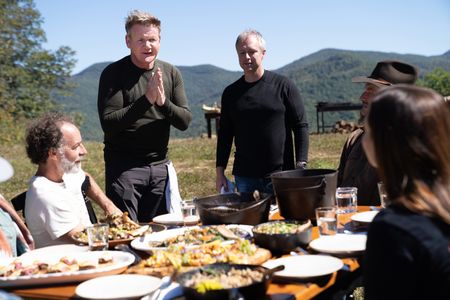 NC - Gordon Ramsay (standing left) and chef William Dissen (standing right) serve their guests during the final cook in the Smoky Mountains of North Carolina. (Credit: National Geographic/Justin Mandel)