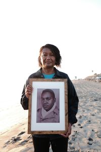 Shauna Dade holds a portrait of her father, Floyd Dade, in San Marco, Calif. Corporal Floyd Dade served with the 761st Black Panther Tank Battalion in WW2. (National Geographic/Fabian Mandujano)