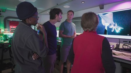 Zoleka Filander, Eric Stackpole, Nathan Robinson and Edith Widder review the angler cam footage and are excited to see the appearance of a Dana Octopus squid. (National Geographic)